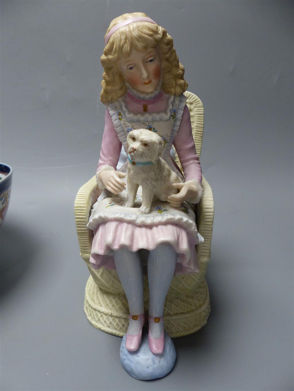 A French coloured biscuit porcelain figure of a seated girl and a Samson armorial bowl, c.1900, diameter 23cm